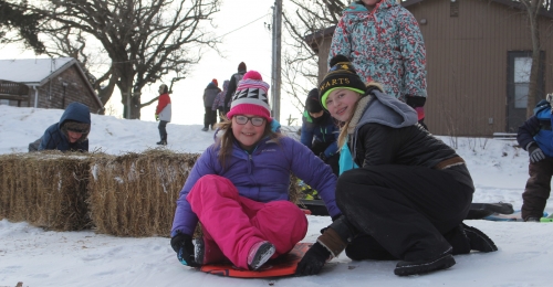 A camper poses on a disk sled just before taking off with assistance from an SK