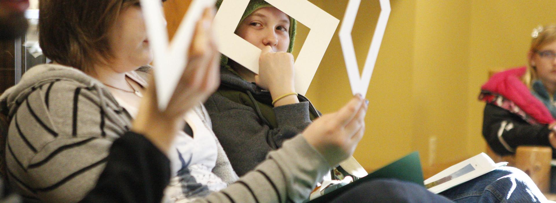 Kids look through cardboard frames to get a perspective of photography