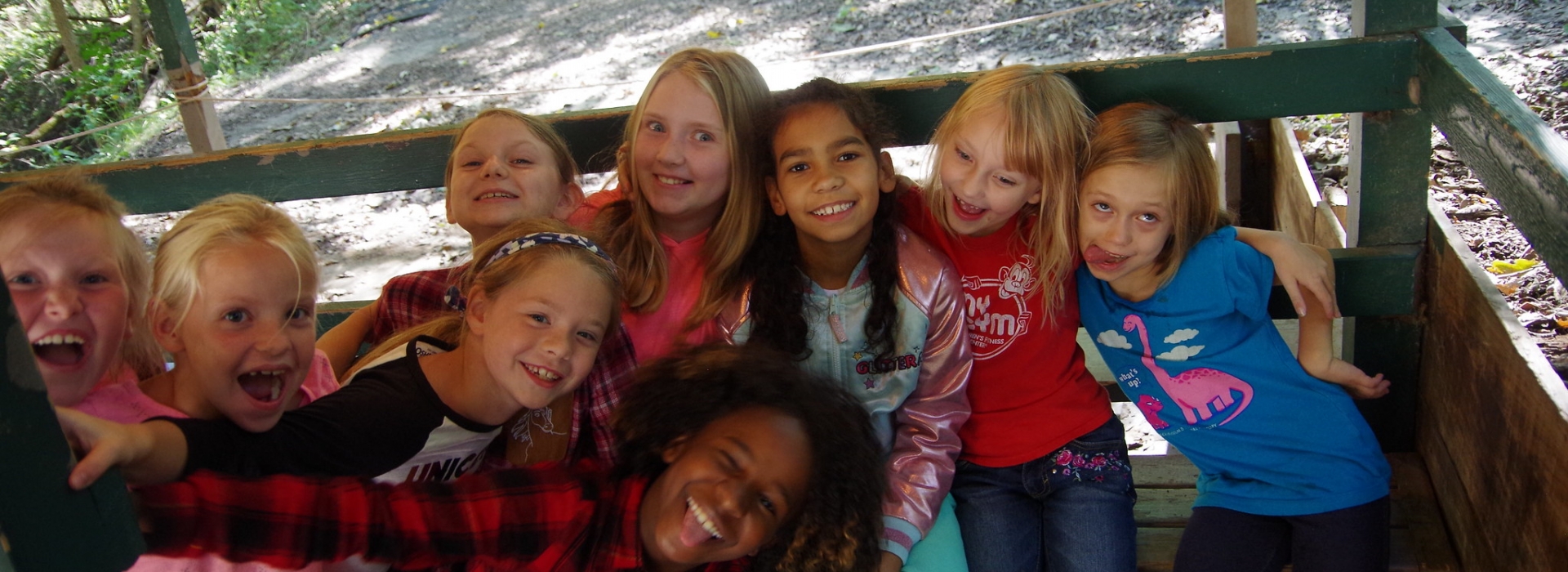 A group of girls make silly faces at the camera while at the Archery range