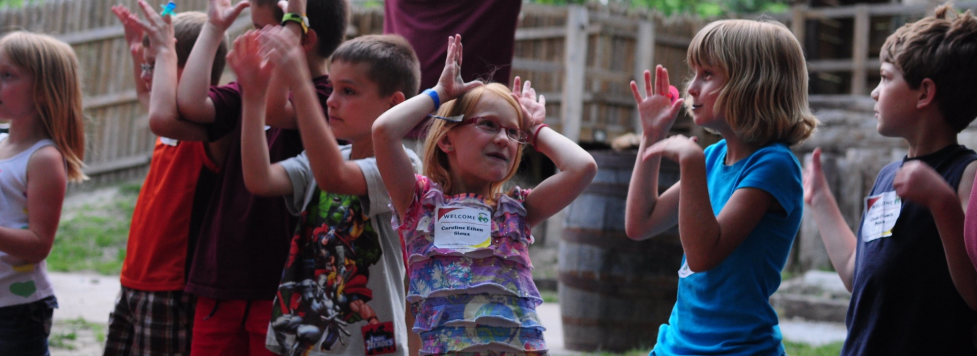 Campers sing songs with their counselor behind them
