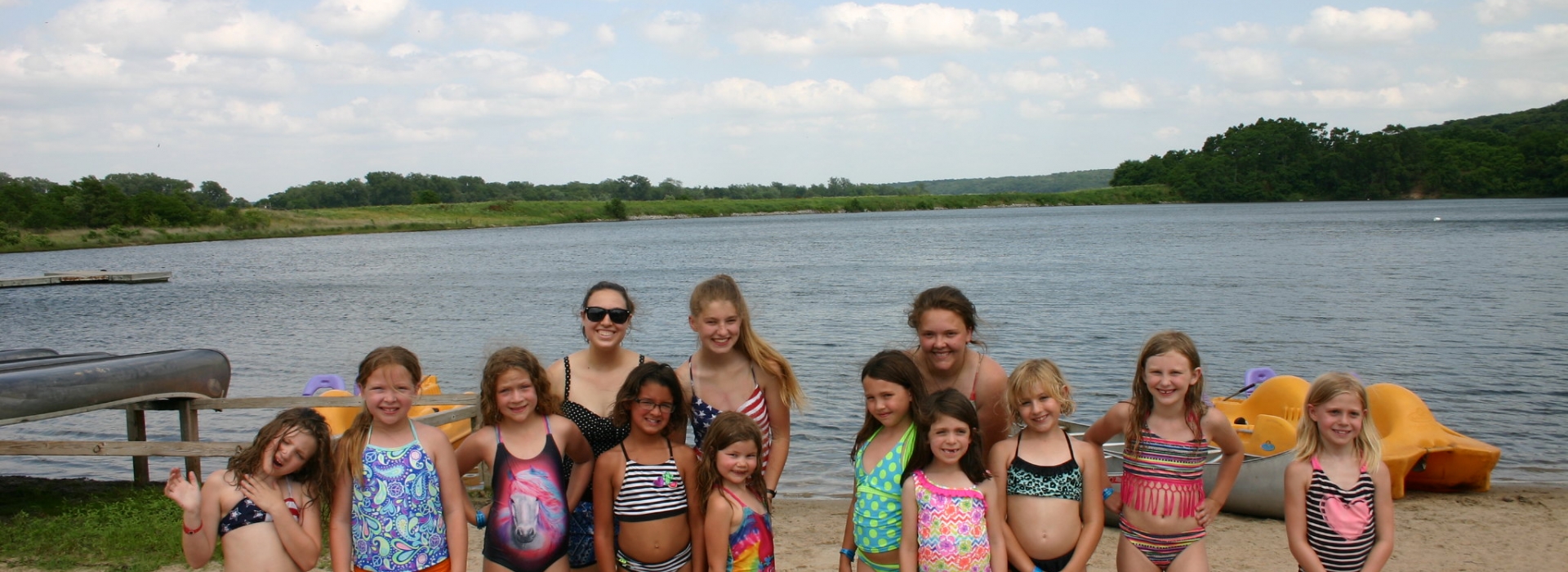 A group of campers pose in front of the lake