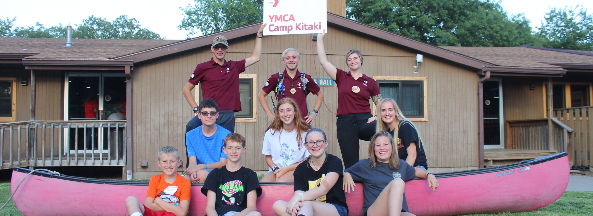A cabin group of Niobrara campers pose with a canoe
