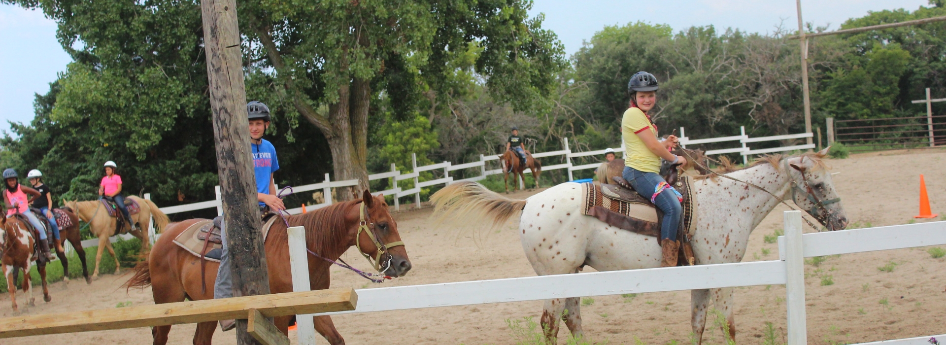 A line of campers on horseback in the arena