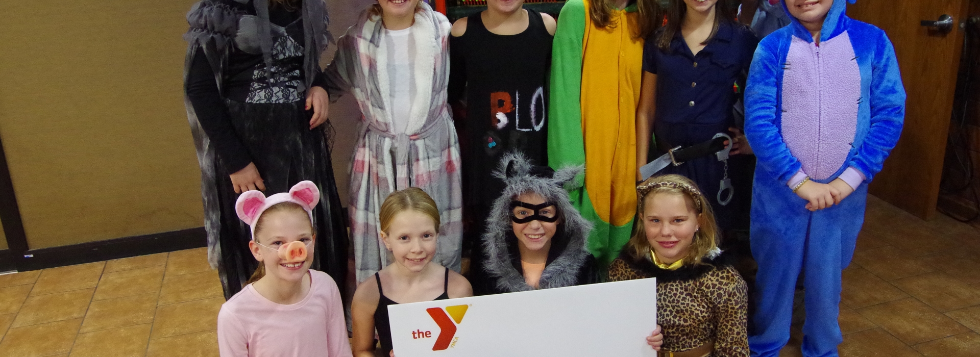 A cabin of campers pose in costumes at Halloween camp