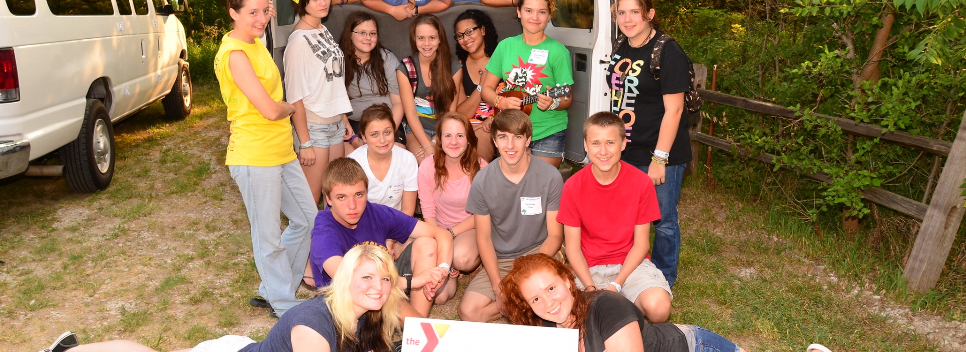 A group of Leadership Campers pose with their van