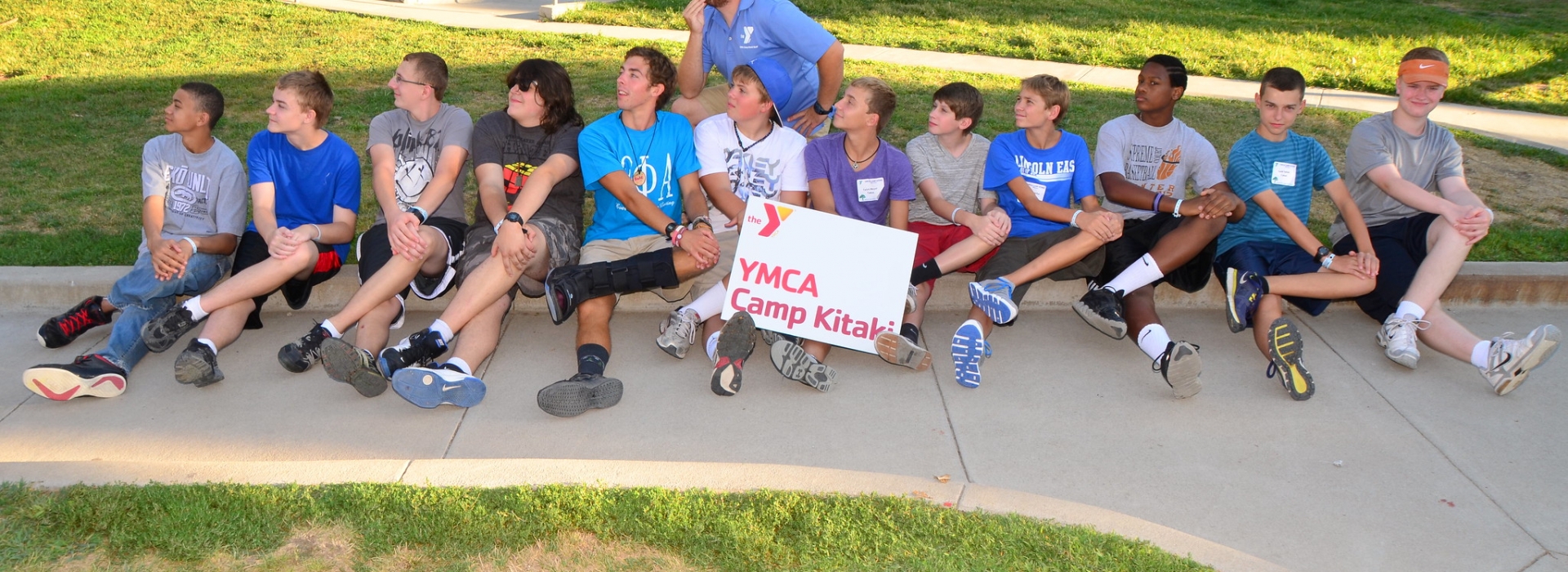 Trailblazers pose for their cabin photo along a curb with one leg crossed