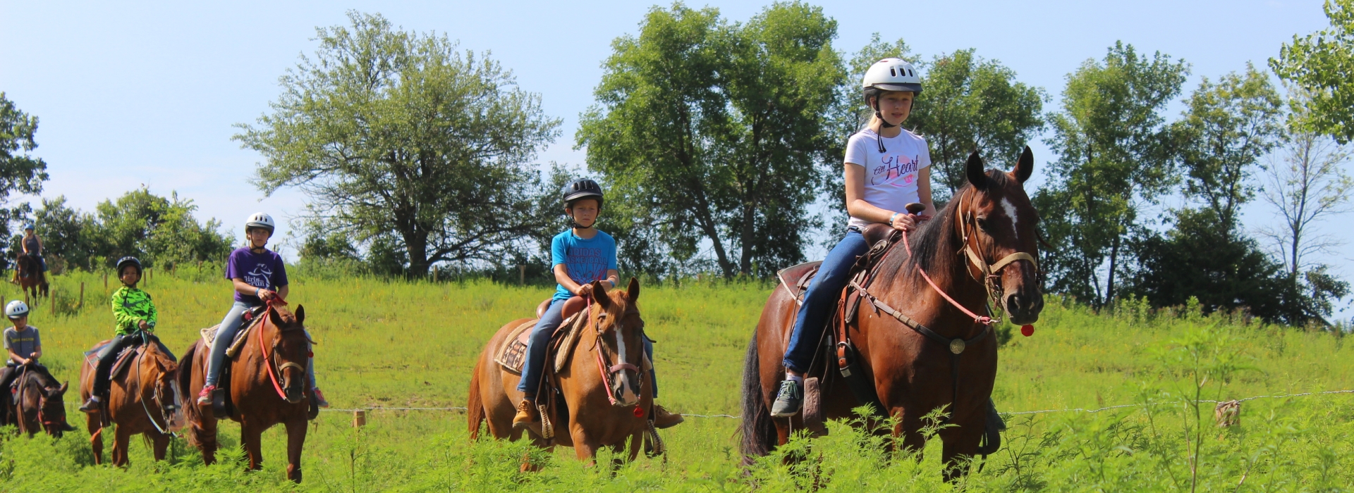 Campers ride the trail through our pasture