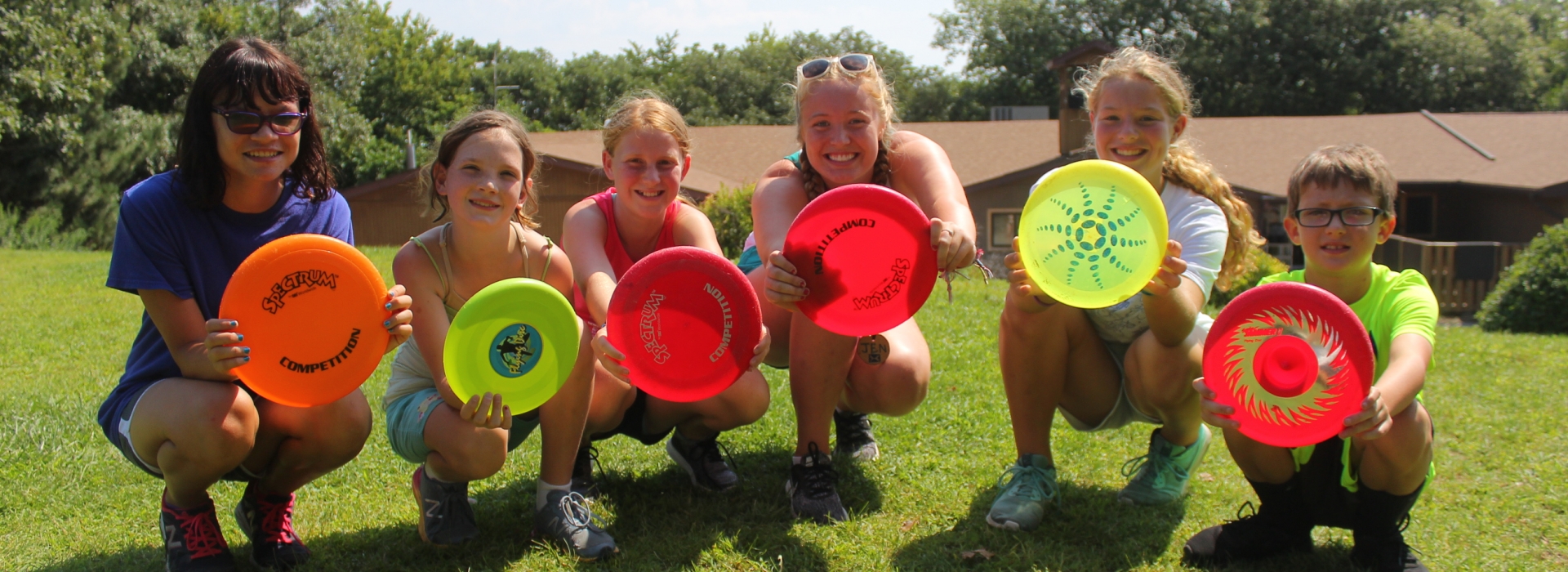 Participants crouch and hold out frisbees