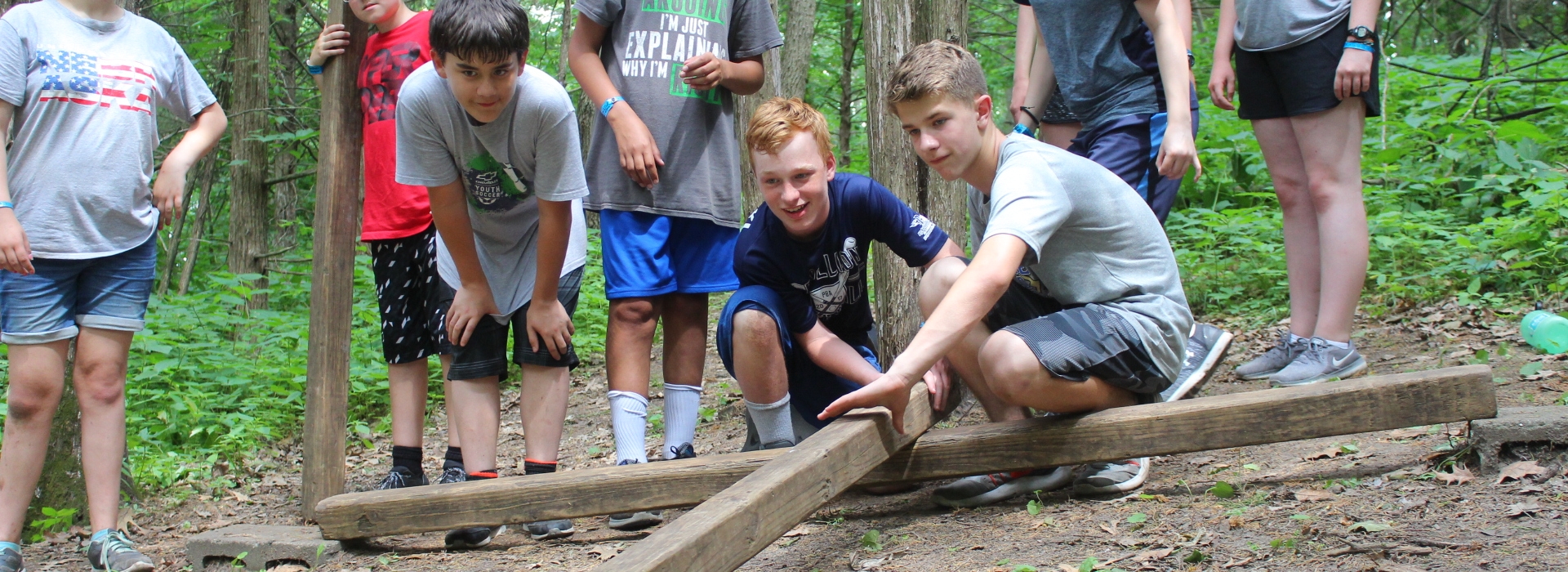 Campers work together to place beams during a teambuilding challenge