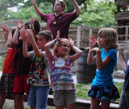 Campers sing songs with their counselor behind them